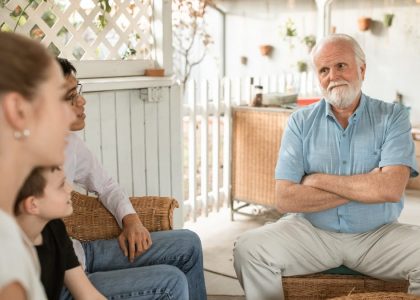 Family gathered indoors, engaged in conversation with a focus on bonds and togetherness.